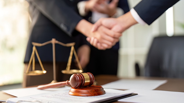 Gavel and scales of justice with handshake — disclosure guidance for agents
